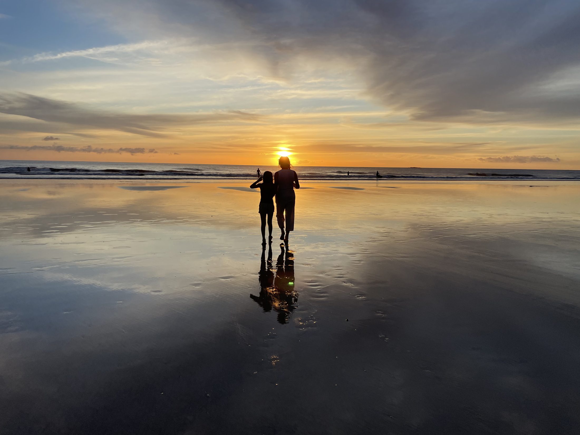 Cassie and her daughter on the sand at sunset, Playa Grande